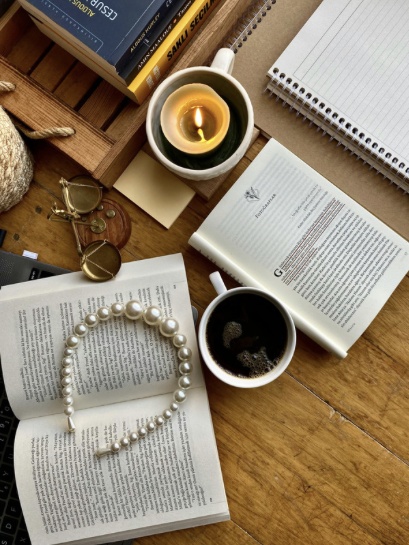 Books, coffee and a candle on a creative workspace